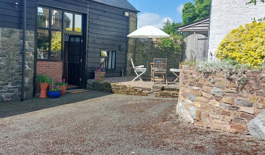 Outside of Granary Cottage, with parking space, Pretty terrace with tables, chairs and sunshade